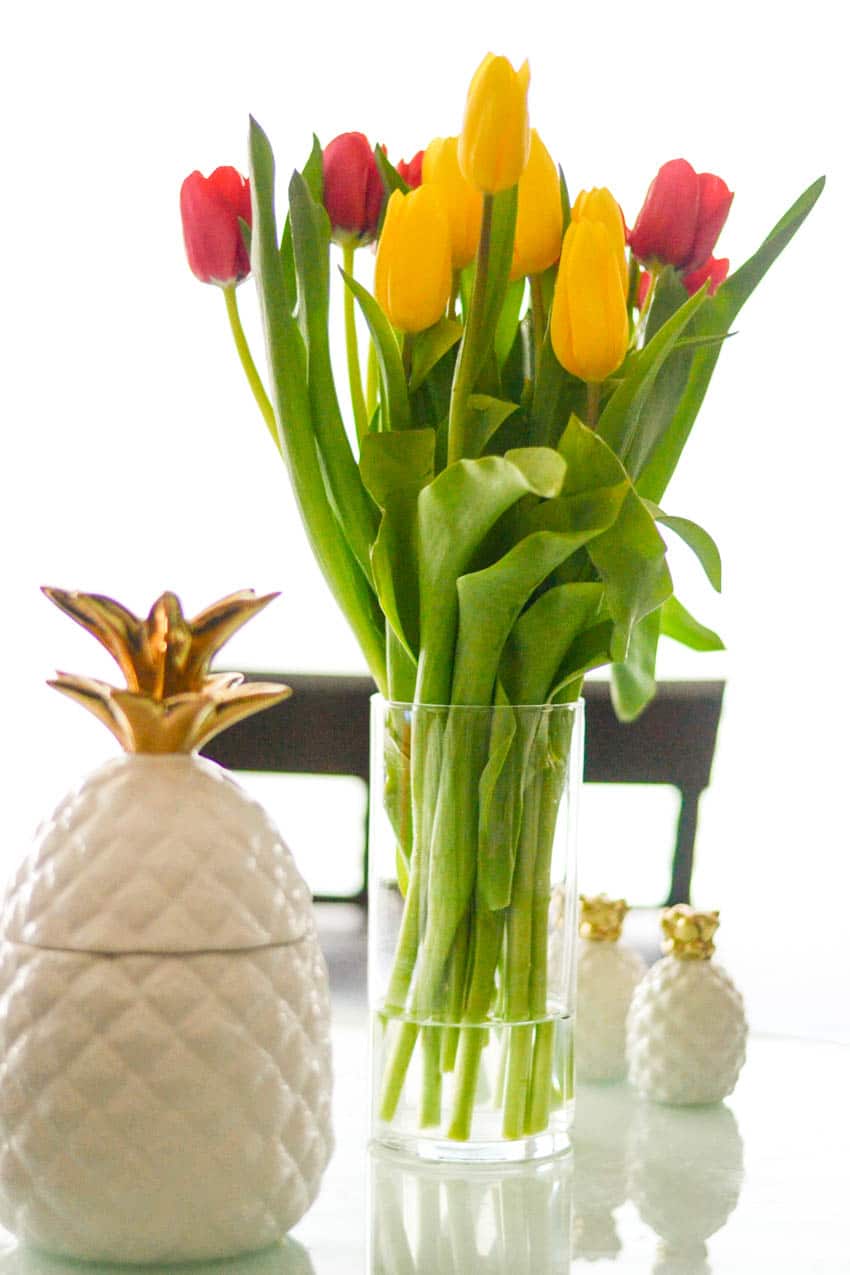Red and yellow tulips with pineapple cookie jar and pineapple salt and pepper shakers