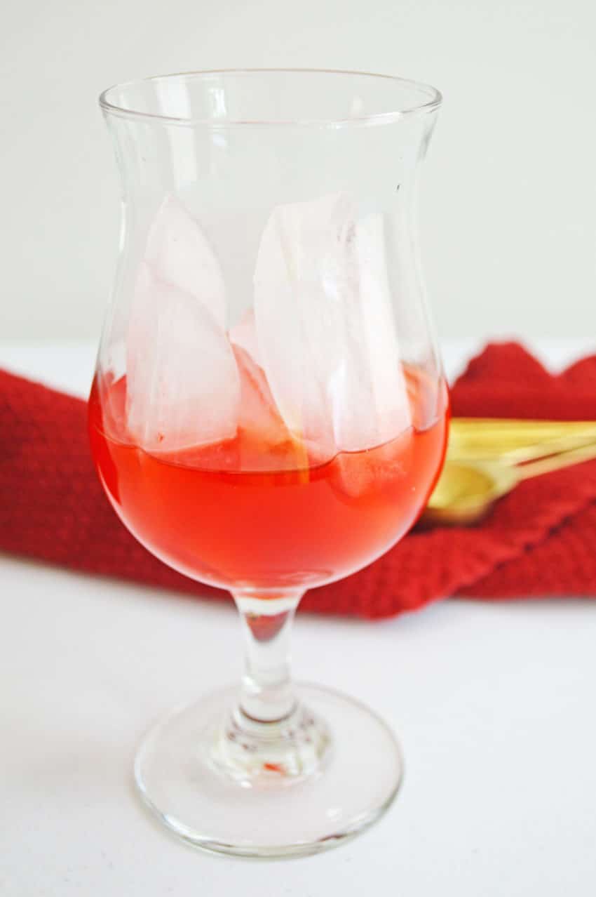 Cherry juice in glass for Pineapple Cherry Rum Punch Cocktail Recipe