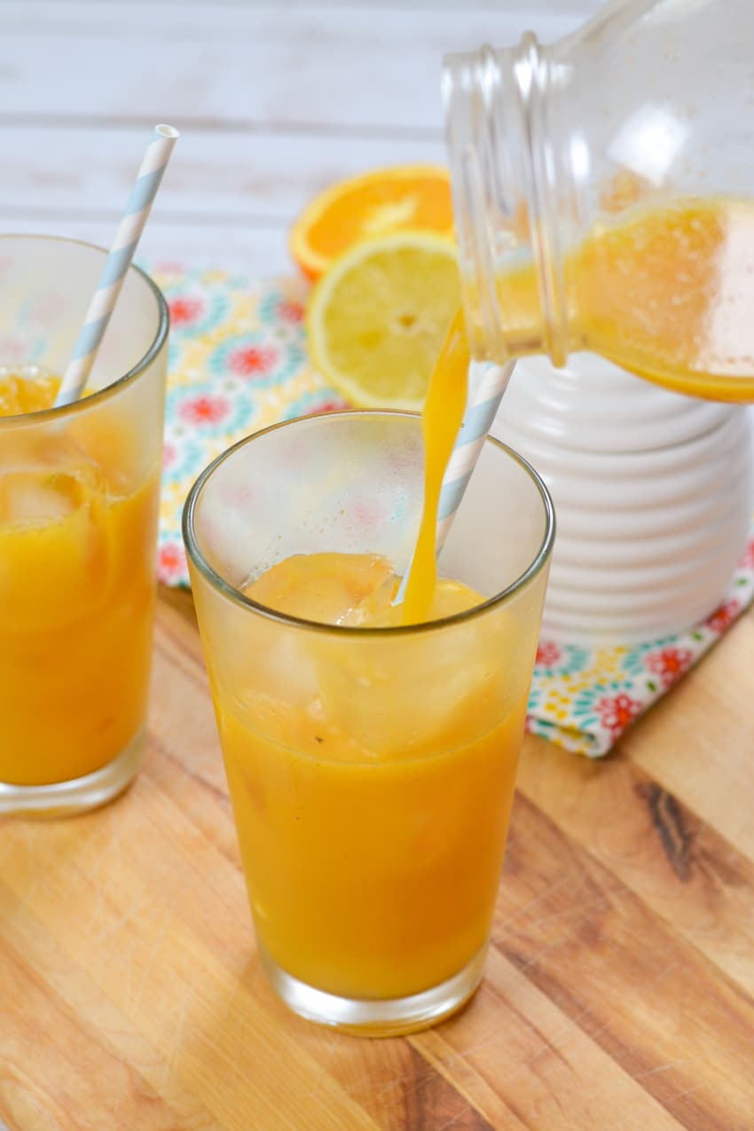 Pouring orange juice mixture to create morning sunshine beet juice drink
