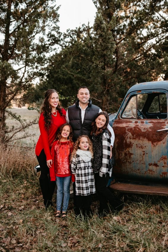 Family Christmas photo in front of an old rusted blue truck