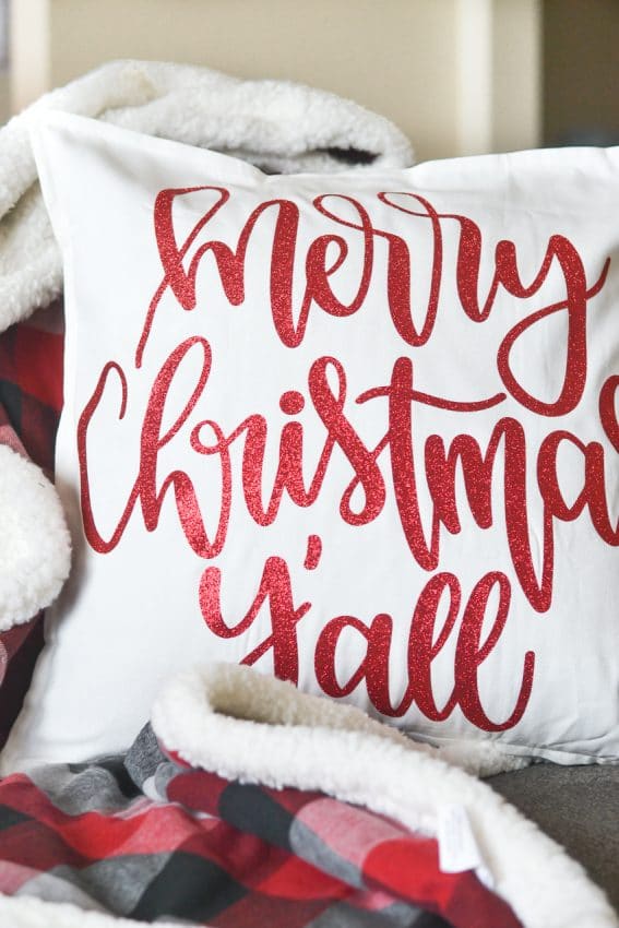 Merry Christmas Y'all text in red glitter on a pillow