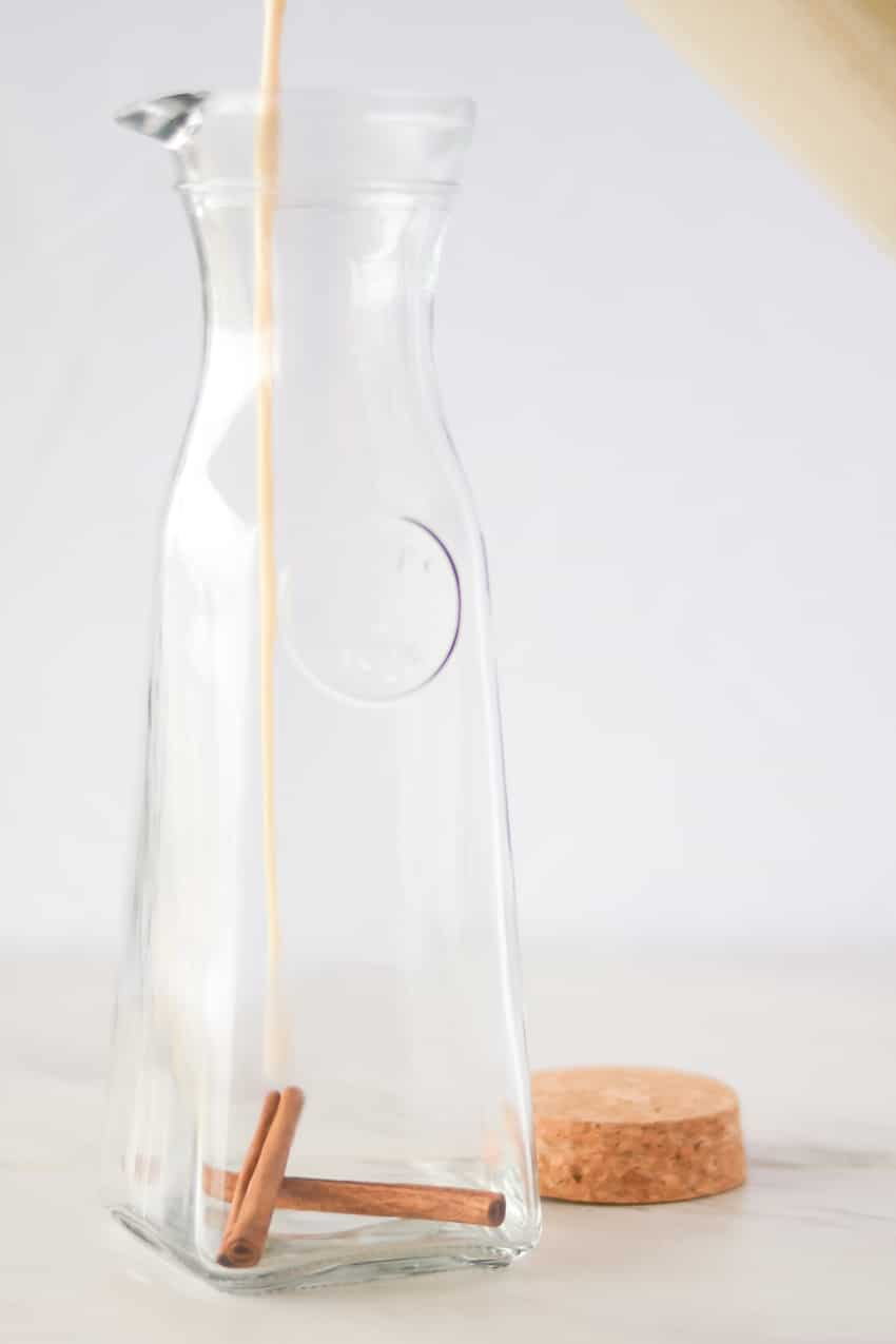 Pouring coquito into glass bottle