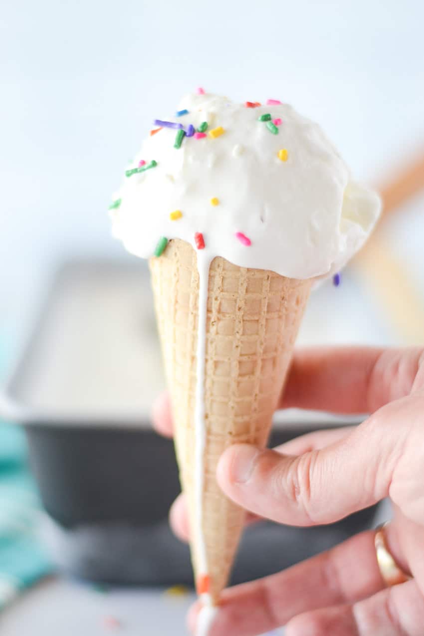 Ice cream scooped into a sugar cone with sprinkles on top