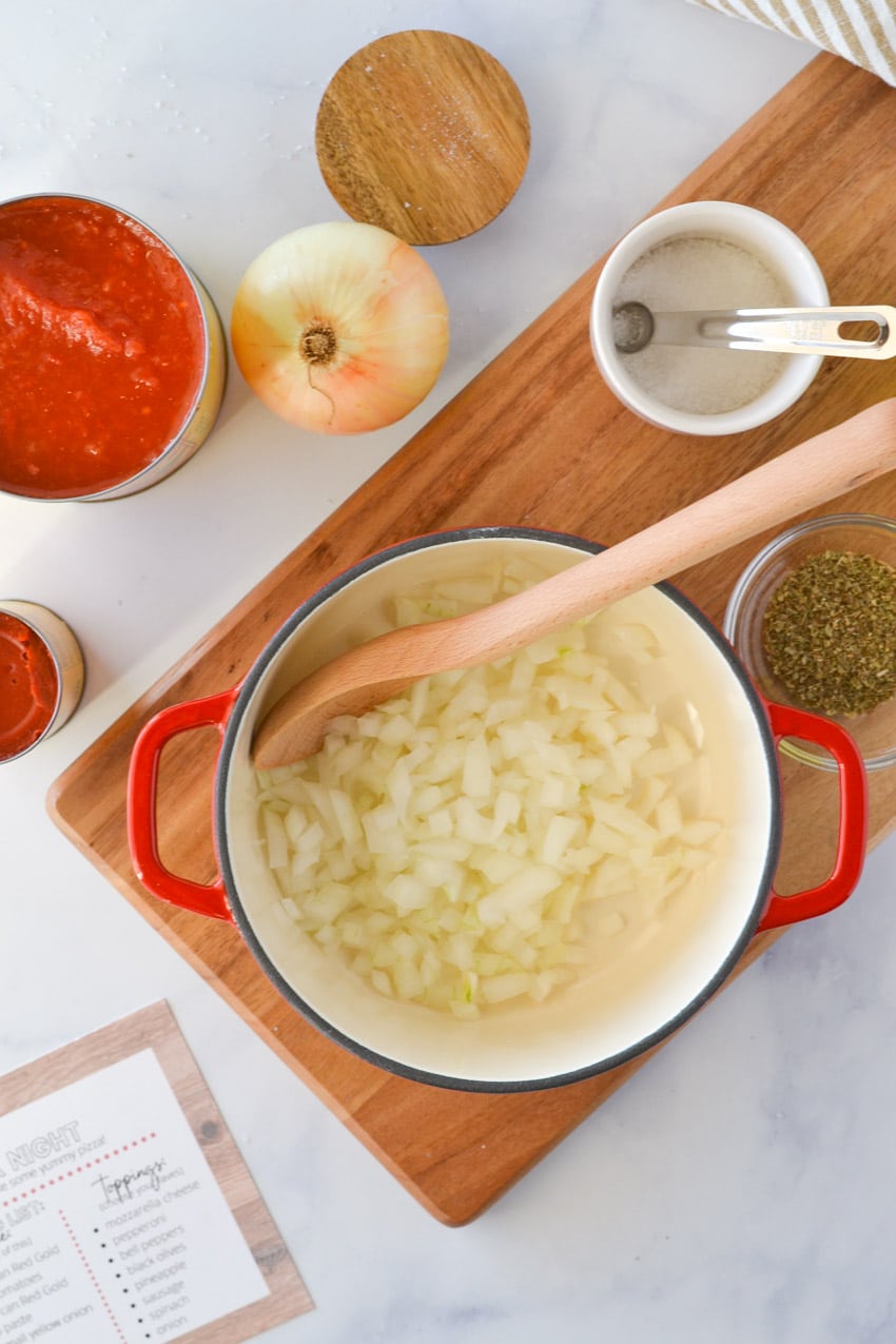 ingredients for homemade pizza sauce on cutting board and in sauce pan