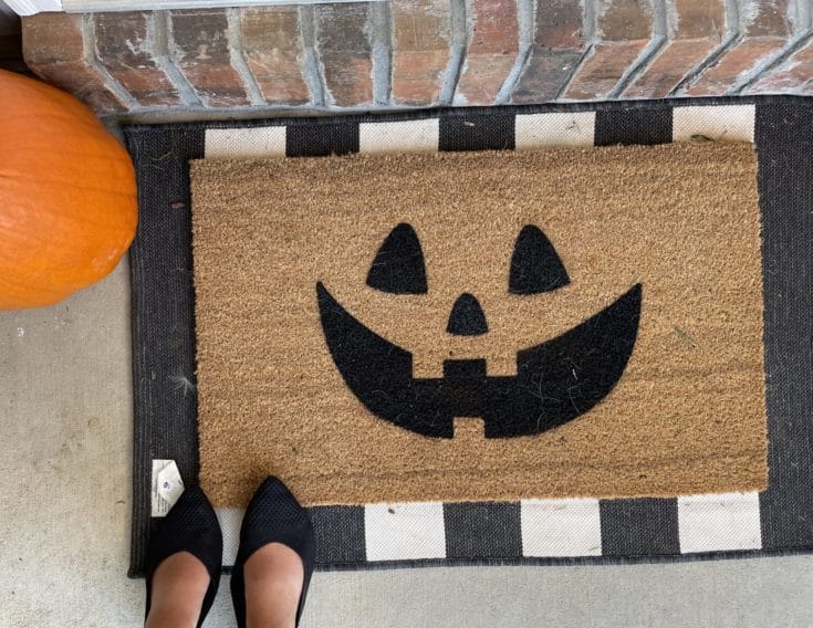 jack-o-lantern face welcome mat on black and white decorative mat