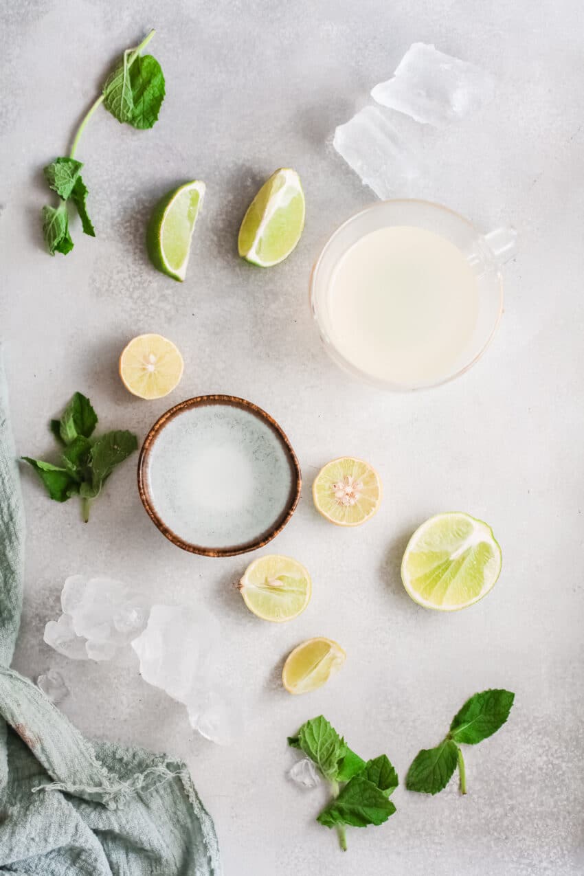 Ingredients to make Frozen Caipirinha on a grey marble background
